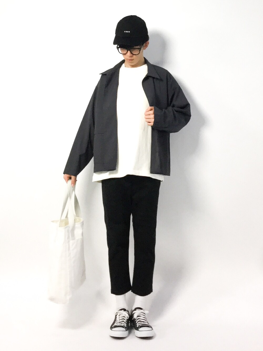 ブラック系のスニーカー、ブラック系のチノパンツ、ホワイト系のスウェットを着用したメンズの春コーディネートの1枚目の写真