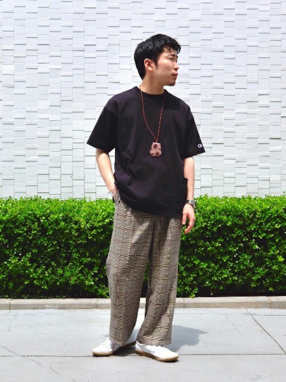 ブラック系のTシャツ/カットソー、ベージュ系のスラックス、ホワイト系のスニーカーを着用したメンズの春コーディネートの1枚目の写真