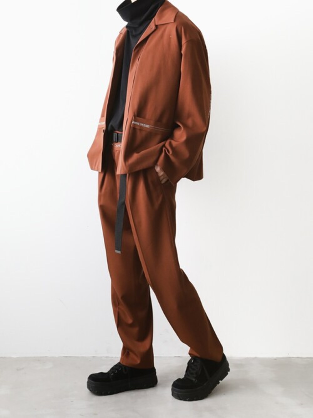 ブラウン系のブルゾン、ブラック系のTシャツ/カットソー、ブラウン系のスラックスを着用したメンズの秋コーディネートの1枚目の写真