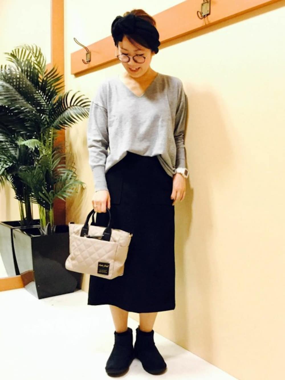 ブラック系のスカート、グレー系のニット/セーター、ブラック系のブーツを着用したレディースの冬コーディネートの1枚目の写真