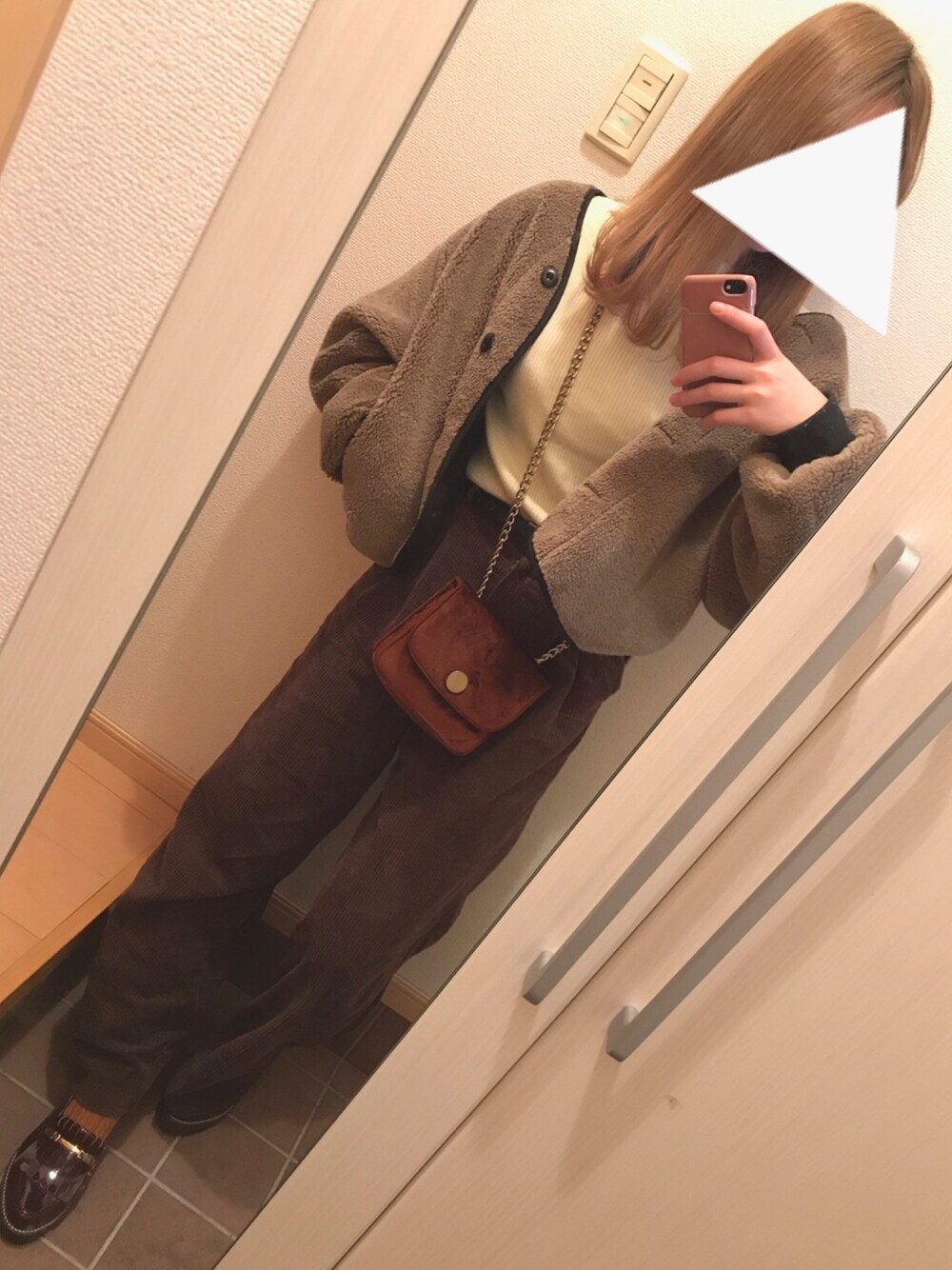 ブラック系のブルゾン、ホワイト系のニット/セーター、ブラウン系のショルダーバッグを着用したレディースの冬コーディネートの1枚目の写真