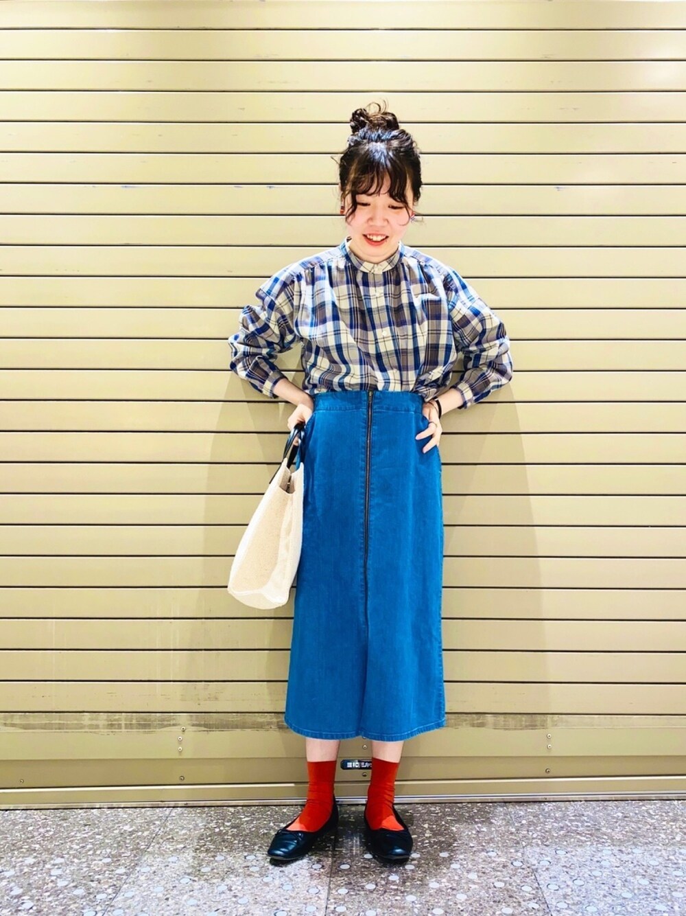 ブルー系のシャツ/ブラウス、イエロー系のトートバッグ、ブルー系のデニムスカートを着用したレディースの春コーディネートの1枚目の写真