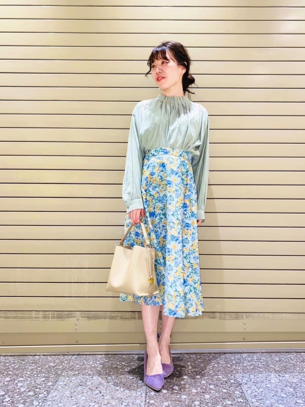 グリーン系のシャツ/ブラウス、グリーン系のスカート、ベージュ系のショルダーバッグを着用したレディースの春コーディネートの1枚目の写真