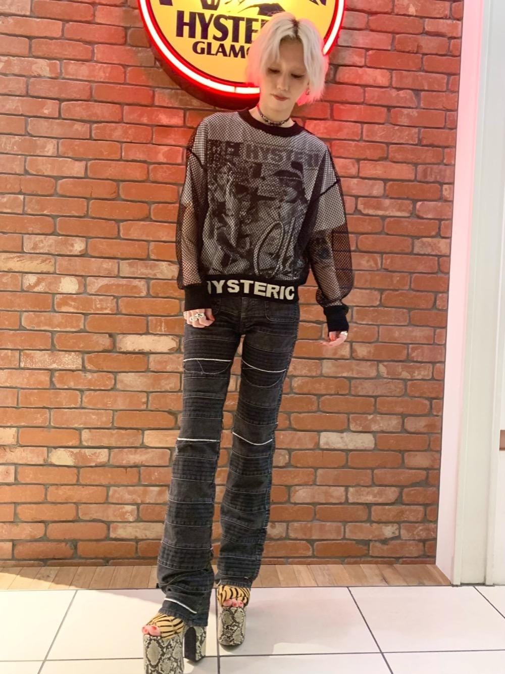 ブラック系のデニムパンツ、ホワイト系のTシャツ/カットソー、ブラック系のニット/セーターを着用したレディースの春コーディネートの1枚目の写真