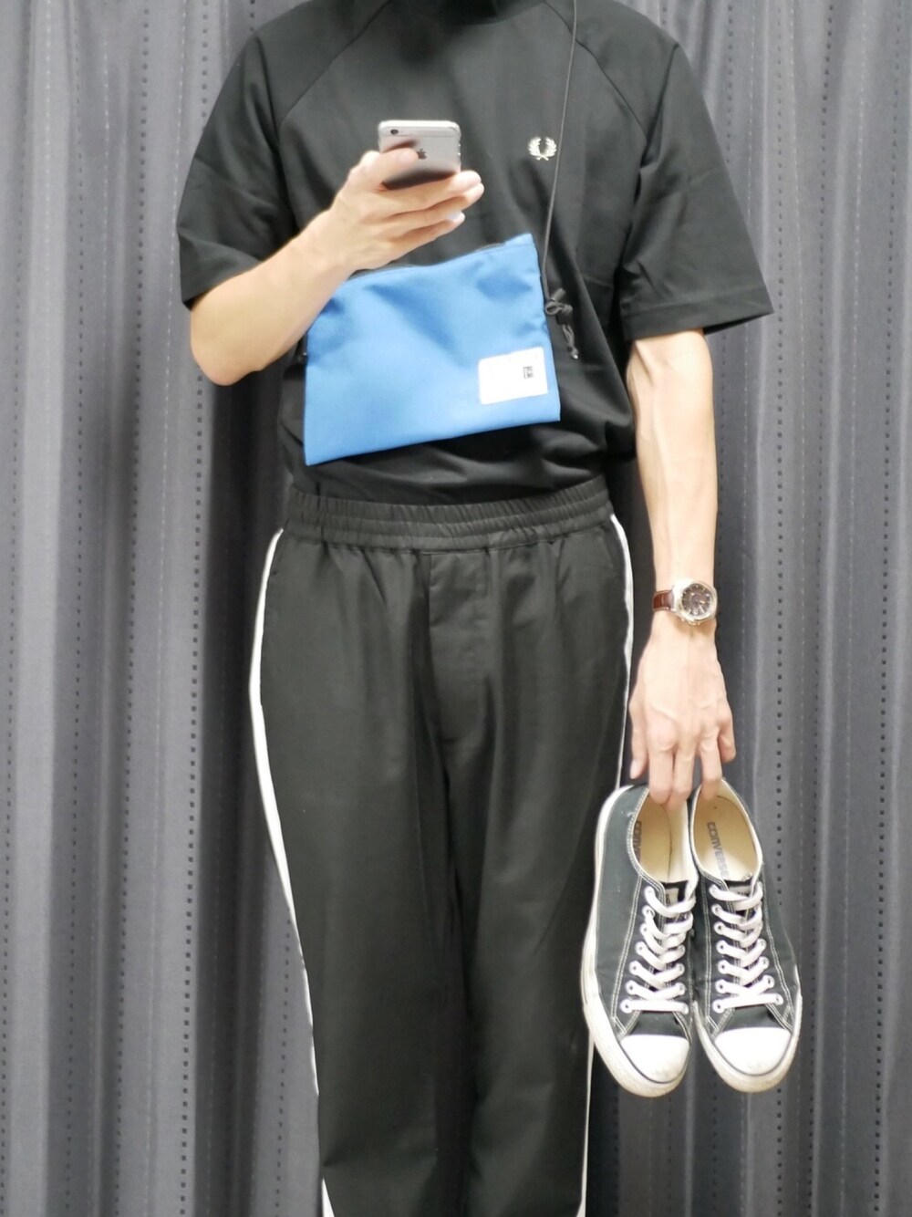 ブラック系のTシャツ/カットソー、ブラック系のスラックス、ブルー系のショルダーバッグを着用したメンズの夏コーディネートの1枚目の写真