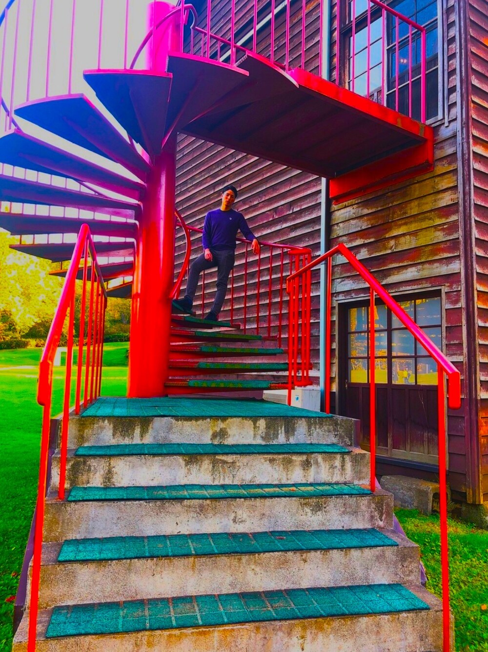 ブラウン系のスラックス、ブラック系のスニーカー、パープル系のニット/セーターを着用したメンズの春コーディネートの1枚目の写真