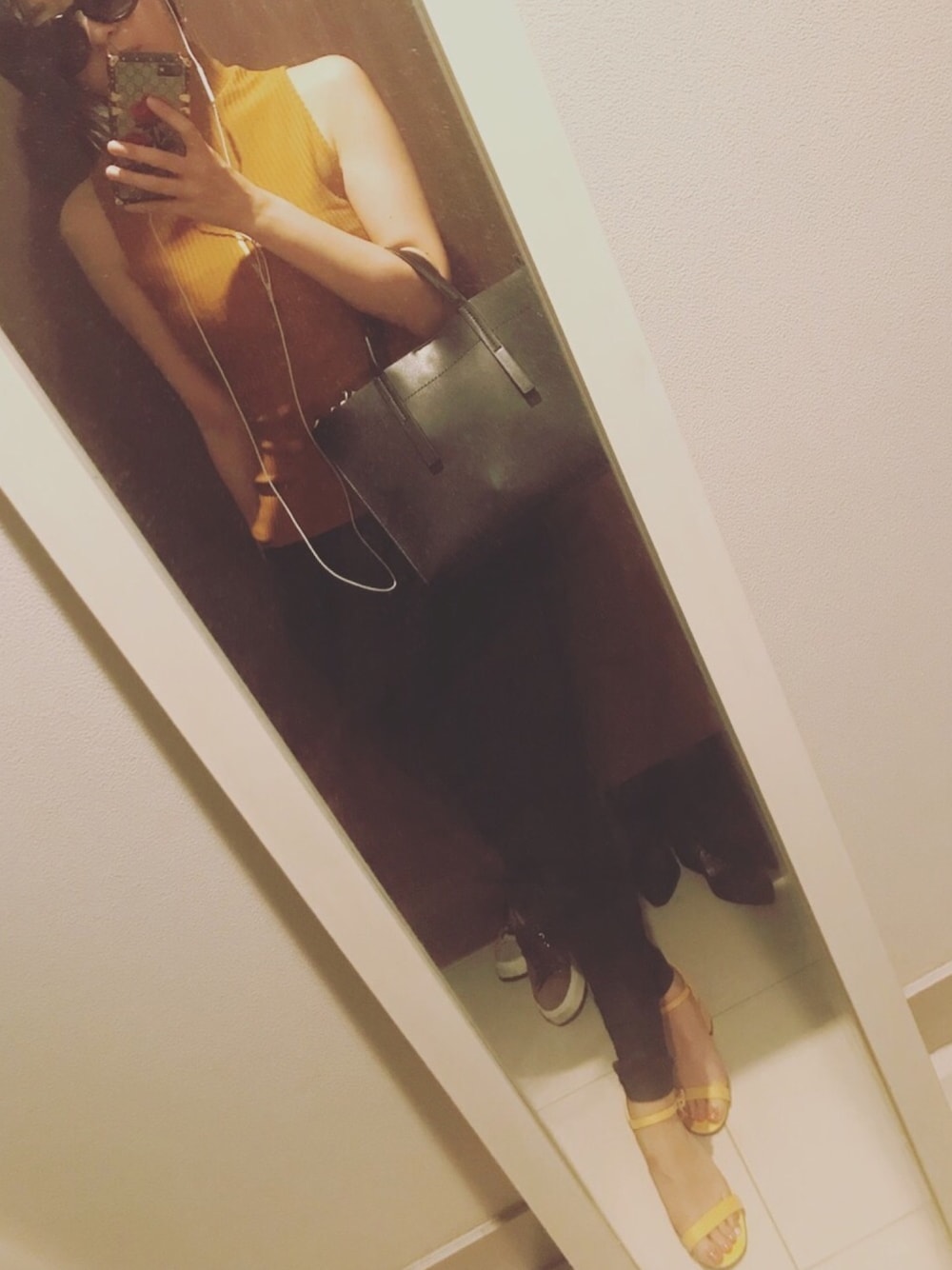 ブラック系のショルダーバッグ、イエロー系のサンダル、ゴールド系のTシャツ/カットソーを着用したレディースの夏コーディネートの1枚目の写真