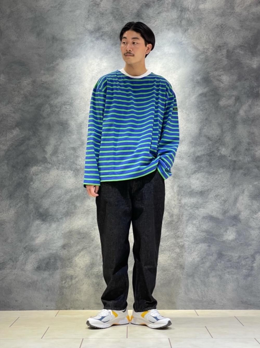 ブラック系のデニムパンツ、ホワイト系のスニーカー、ブルー系のTシャツ/カットソーを着用したメンズの秋コーディネートの1枚目の写真