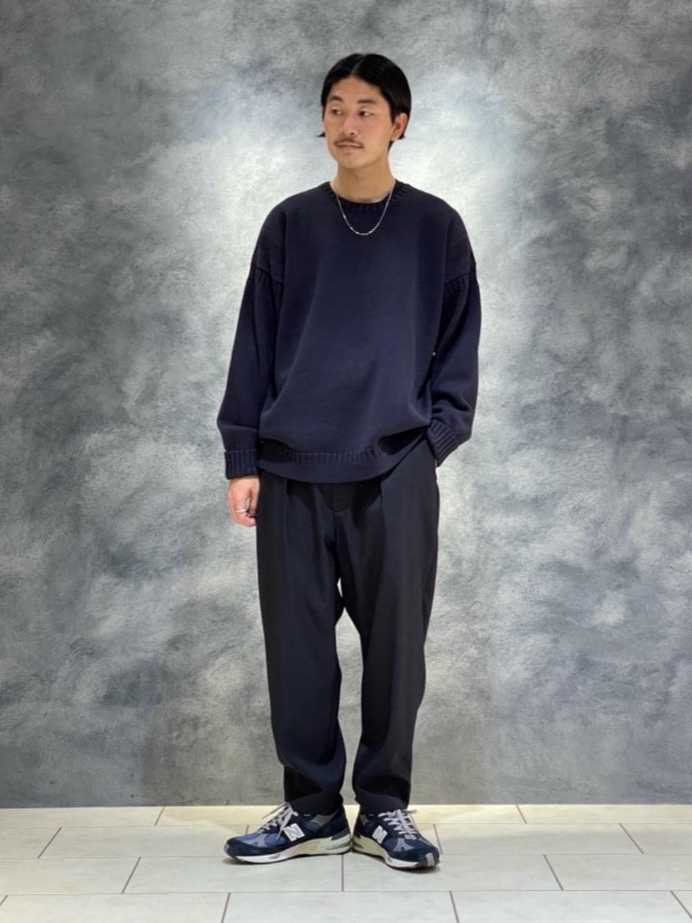 ブラック系のその他パンツ、ブルー系のニット/セーター、シルバー系のネックレスを着用したメンズの秋コーディネートの1枚目の写真