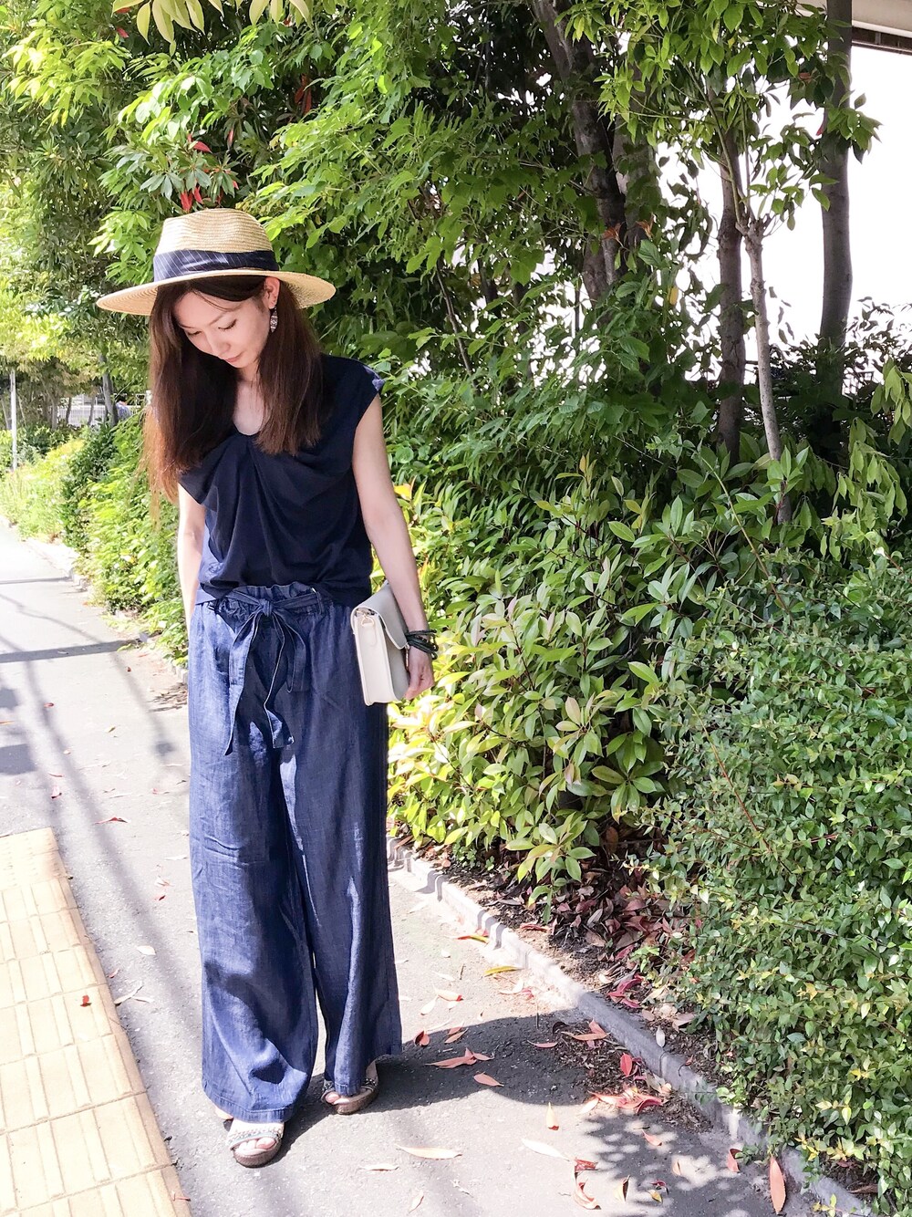 ブルー系のデニムパンツ、ブルー系のTシャツ/カットソー、ベージュ系のハットを着用したレディースの春コーディネートの1枚目の写真