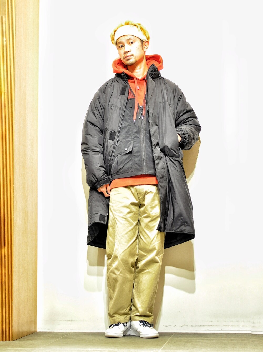 ブラック系のベスト、ブラック系のダウンジャケット/コート、レッド系のパーカーを着用したメンズの冬コーディネートの1枚目の写真