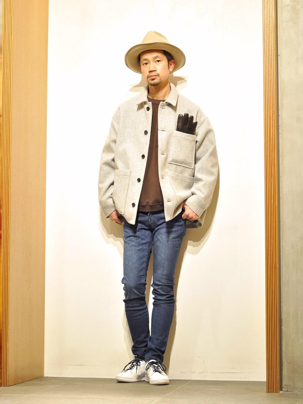 ブラウン系のスウェット、グレー系のカバーオール、ブルー系のデニムパンツを着用したメンズの冬コーディネートの1枚目の写真