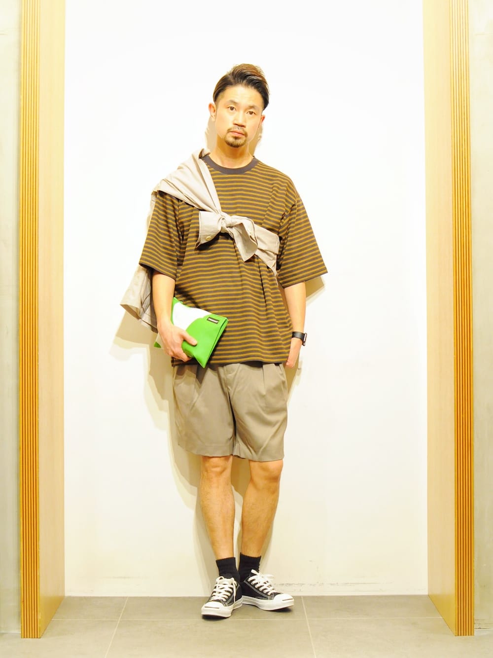 ブラウン系のTシャツ/カットソー、グレー系のブルゾン、ブラック系のスニーカーを着用したメンズの春コーディネートの1枚目の写真