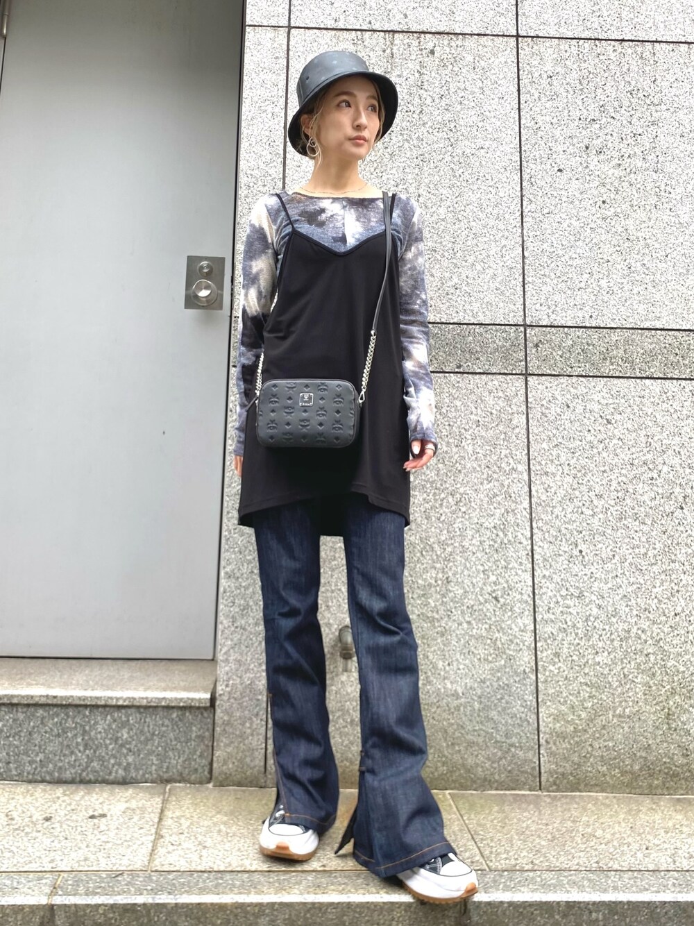 「デニム、ショルダーバッグ、タイダイ柄、レイヤードスタイル、MCM、フレアパンツ、バケットハット、韓国ファッション、フレアデニム」｜「MCMのMCM/エムシーエム/〈クララ〉クロスボディポーチ - モノグラムレザー（ボディバッグ/ウエストポーチ、ブラック系）」を使った、hanae maruiさん（レディース・155cm）の春コーディネートの1枚目の写真