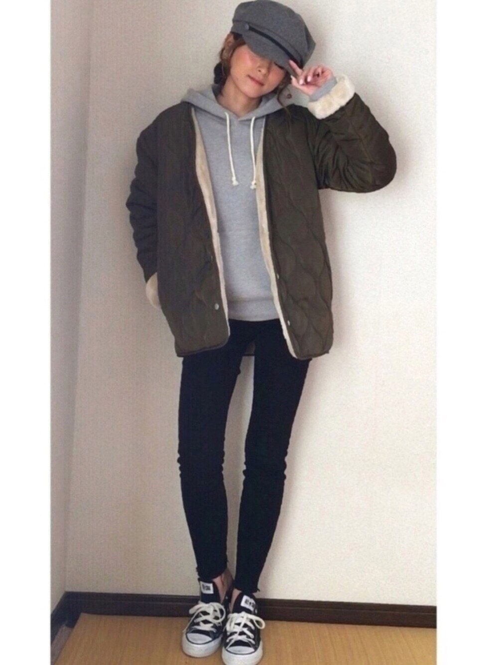 グリーン系のブルゾン、ブラック系のデニムパンツ、ブラック系のスニーカーを着用したレディースの冬コーディネートの1枚目の写真