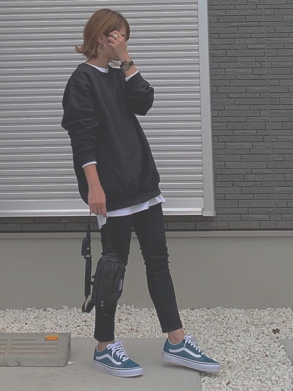 ブラック系のスウェット、ホワイト系のTシャツ/カットソー、ブラック系のデニムパンツを着用したレディースの秋コーディネートの1枚目の写真