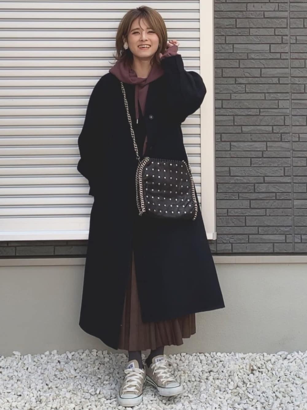 ブルー系のその他アウター、ブラウン系のパーカー、ブラック系のハンドバッグを着用したレディースの冬コーディネートの1枚目の写真