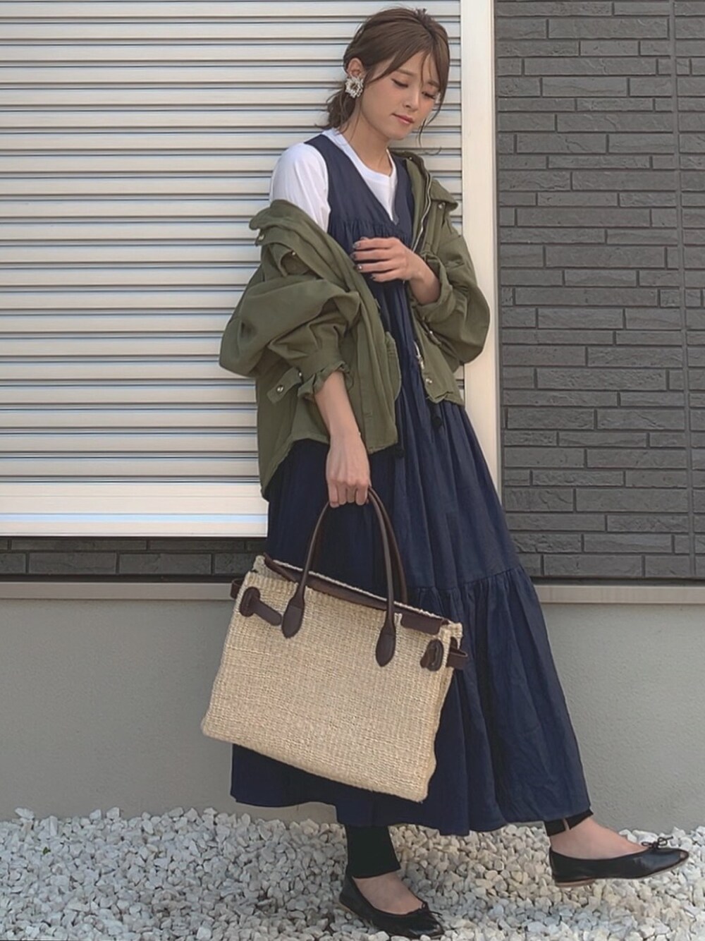 ブルー系のワンピース、グリーン系のミリタリージャケット、ブラック系のバレエシューズを着用したレディースの春コーディネートの1枚目の写真