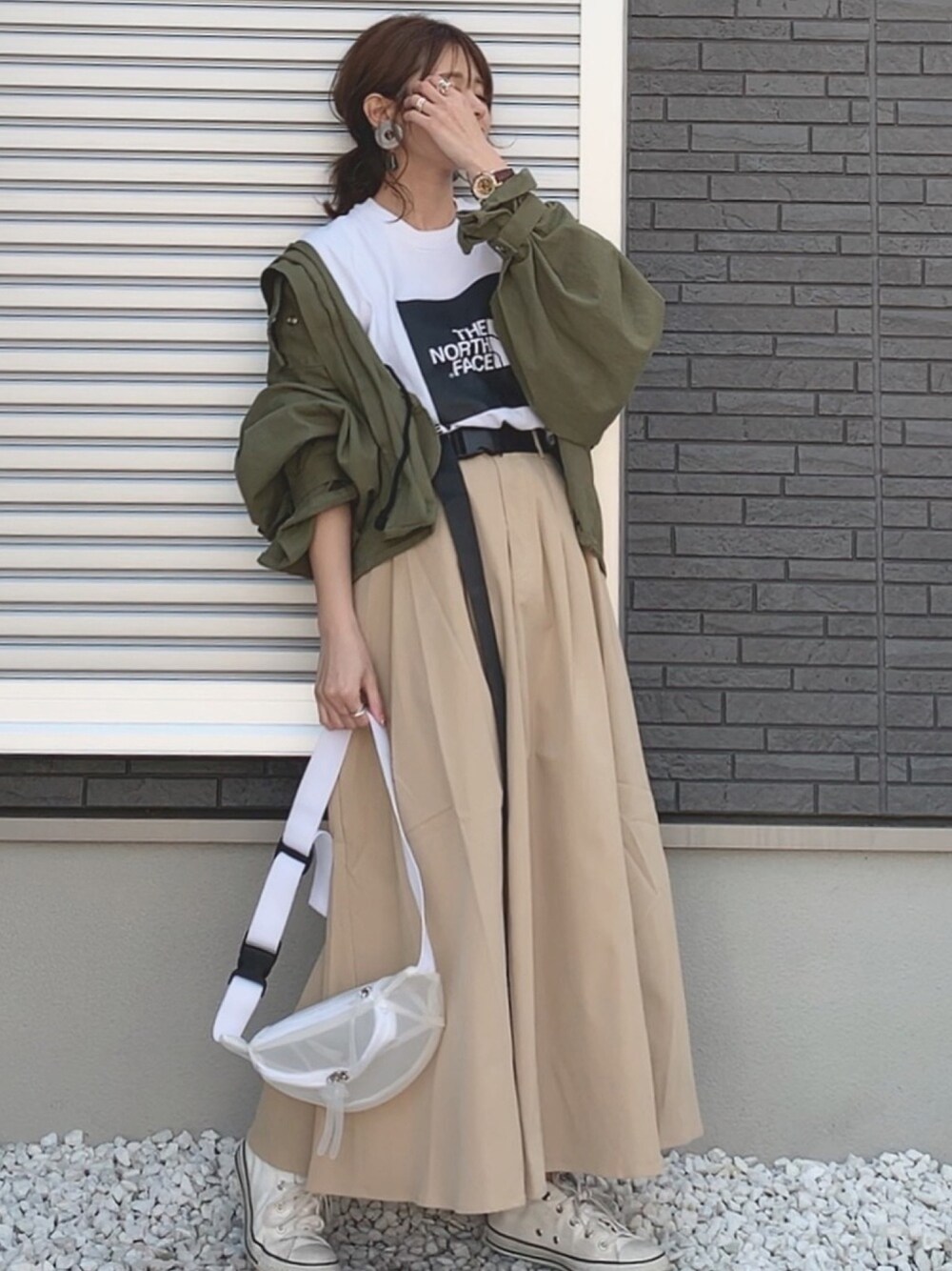 ホワイト系のTシャツ/カットソー、グリーン系のミリタリージャケット、ベージュ系のスカートを着用したレディースの春コーディネートの1枚目の写真