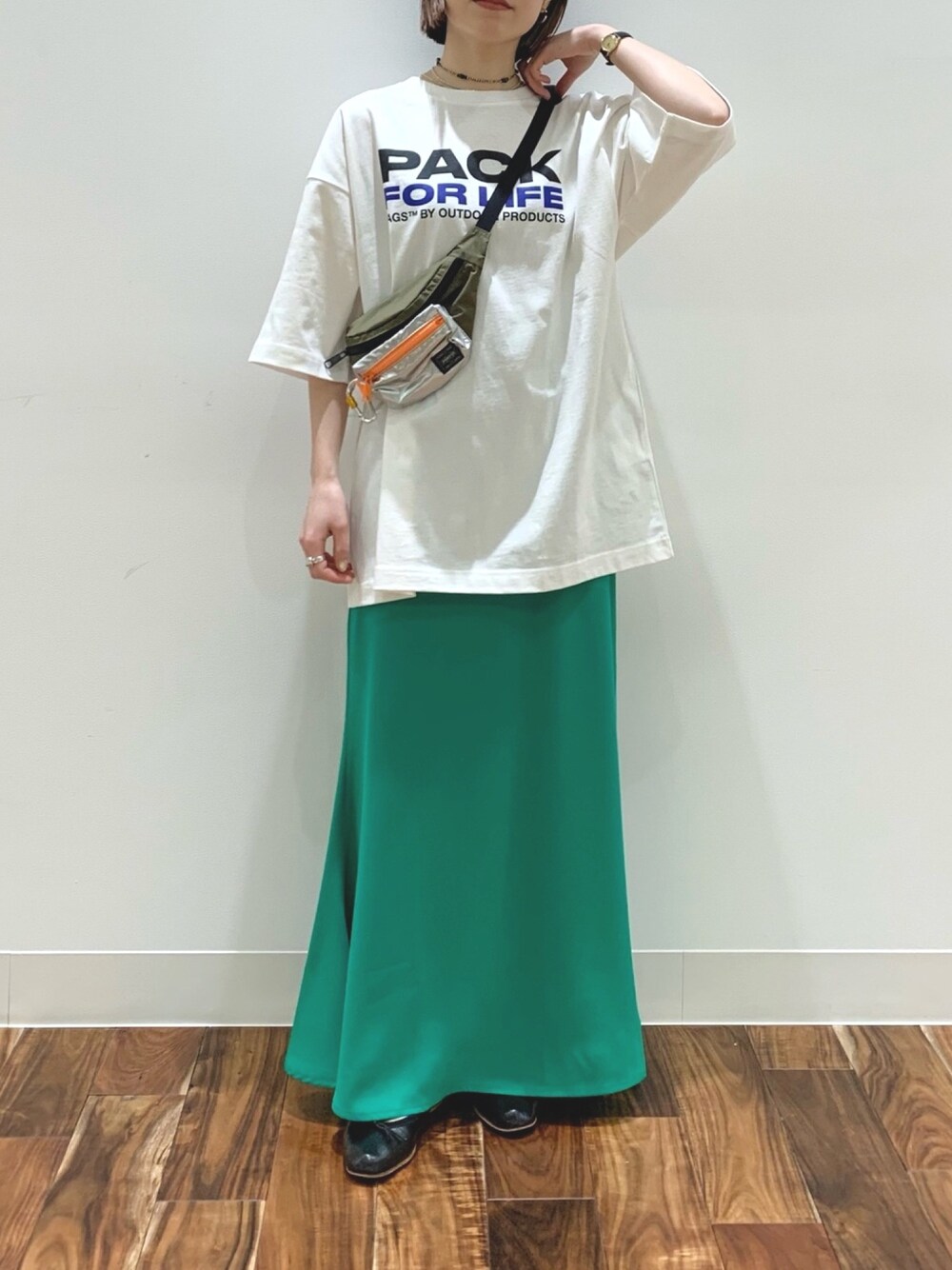 グリーン系のスカート、ホワイト系のTシャツ/カットソー、グリーン系のボディバッグ/ウエストポーチを着用したレディースの春コーディネートの1枚目の写真