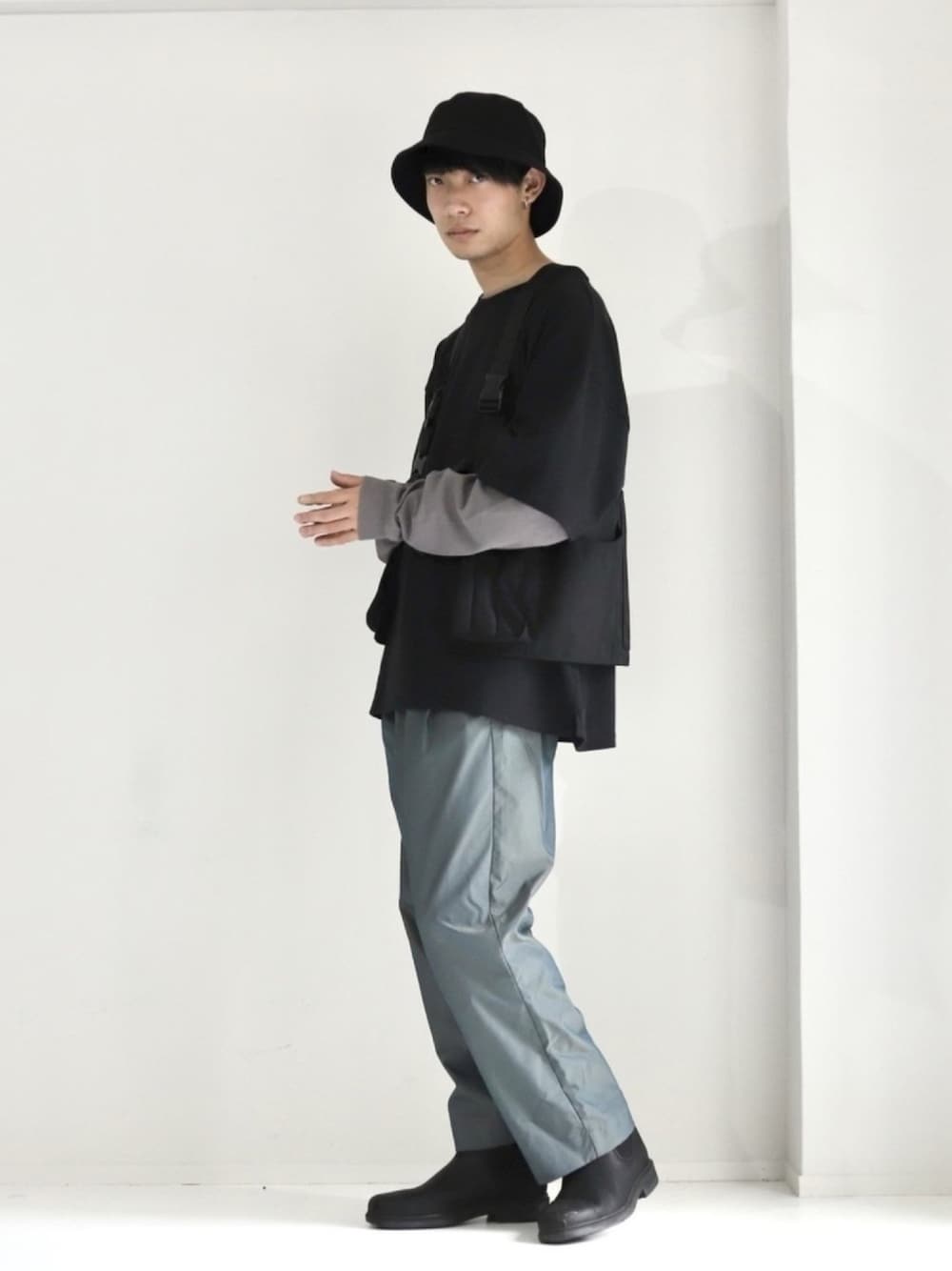 グリーン系のスラックス、ブラック系のTシャツ/カットソー、ブラック系のドレスシューズを着用したメンズの春コーディネートの1枚目の写真
