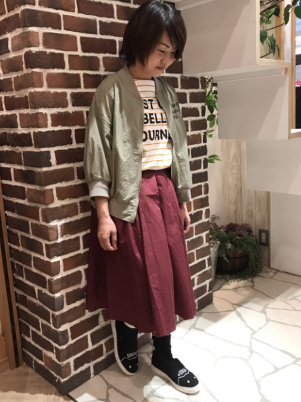 イエロー系のTシャツ/カットソー、グリーン系のブルゾン、パープル系のスカートを着用したレディースの夏コーディネートの1枚目の写真