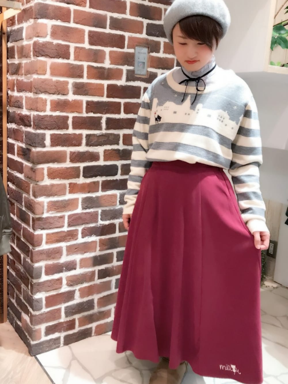 グレー系のニット/セーター、ホワイト系のシャツ/ブラウス、ピンク系のスカートを着用したレディースの冬コーディネートの1枚目の写真