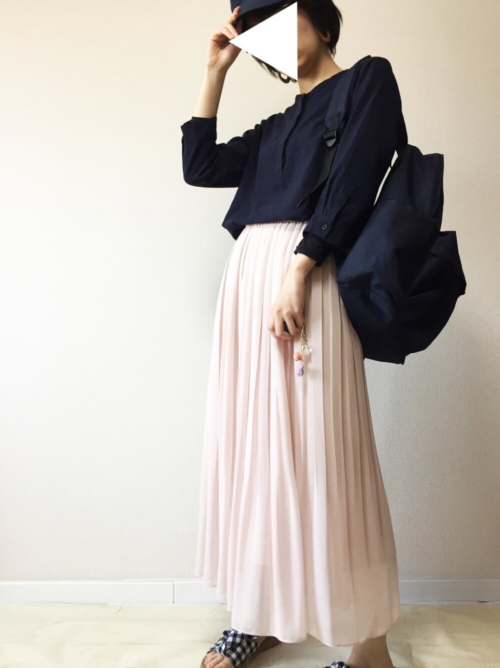 ピンク系のスカート、ブルー系のバックパック/リュック、ブルー系のシャツ/ブラウスを着用したレディースの春コーディネートの1枚目の写真