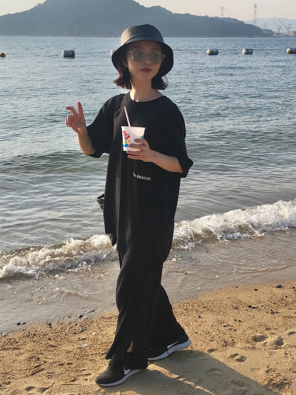 ブラック系のTシャツ/カットソー、ブラック系のショルダーバッグ、ブルー系のパンツを着用したレディースの夏コーディネートの1枚目の写真