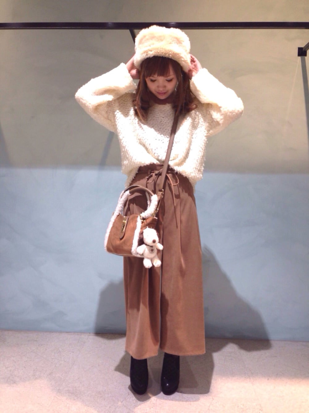 イエロー系のその他パンツ、ホワイト系のニット/セーター、ベージュ系のハットを着用したレディースの冬コーディネートの1枚目の写真