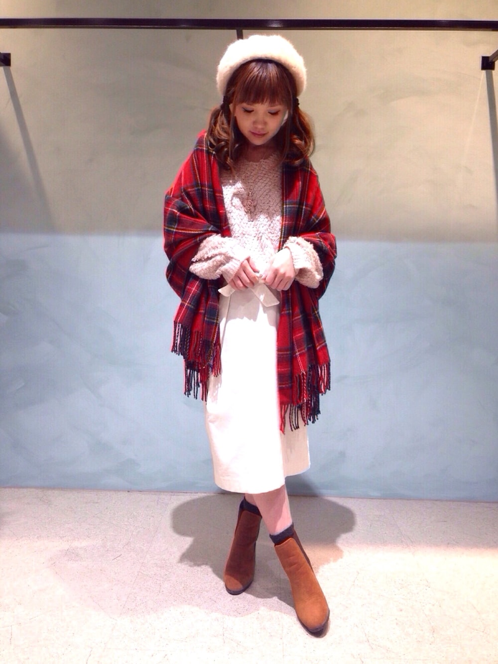 ホワイト系のスカート、ピンク系のニット/セーター、ブラウン系のブーツを着用したレディースの冬コーディネートの1枚目の写真