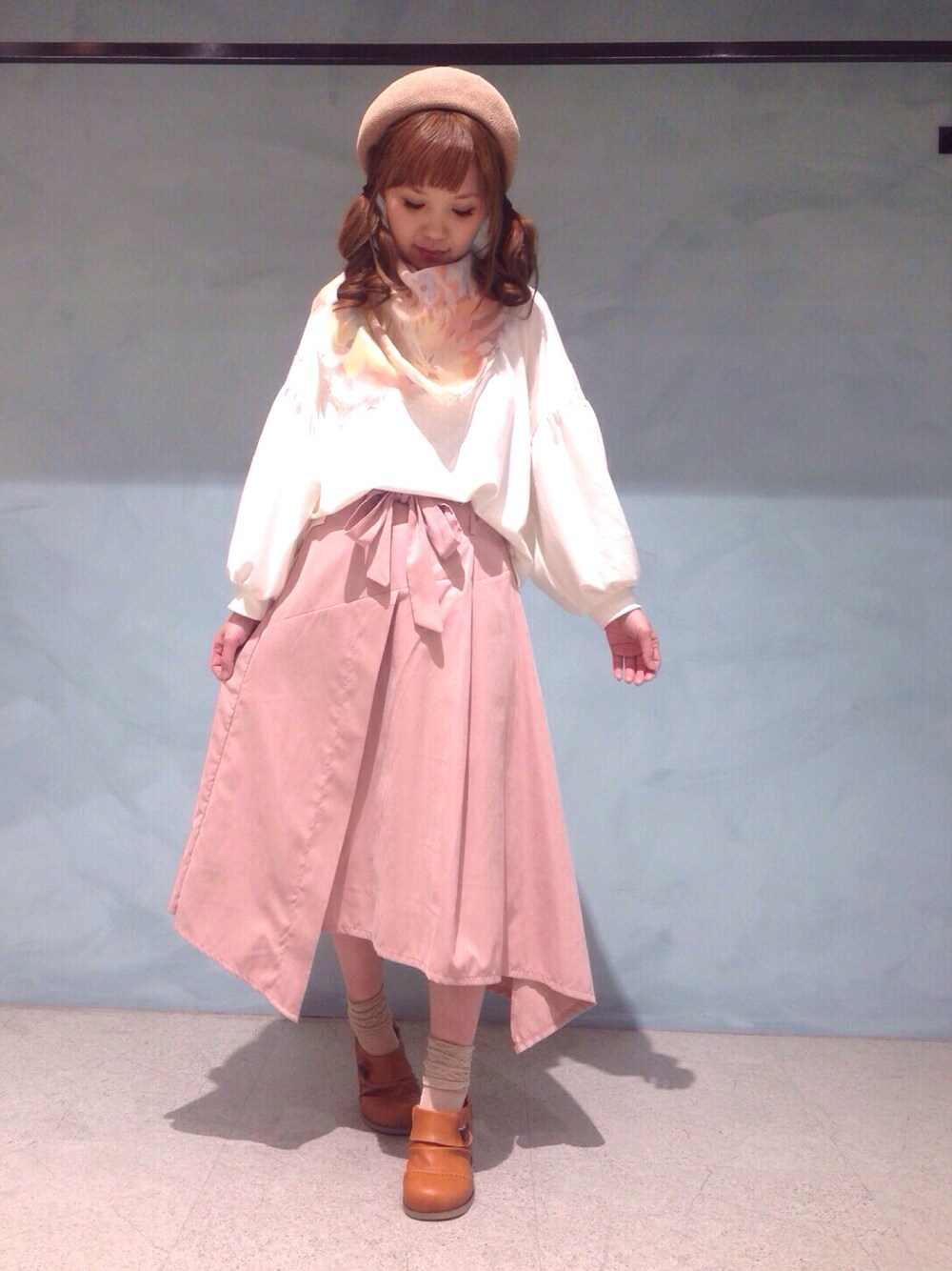 ピンク系のスカート、ブラウン系のシューズ、ホワイト系のTシャツ/カットソーを着用したレディースの冬コーディネートの1枚目の写真