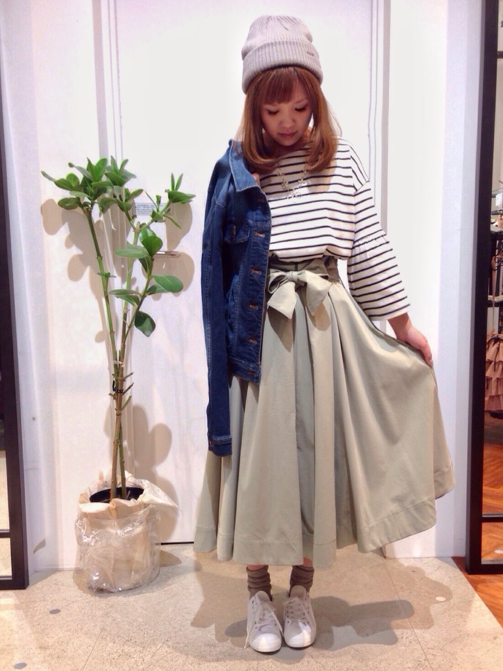 ブルー系のデニムジャケット、ホワイト系のTシャツ/カットソー、グリーン系のスカートを着用したレディースの春コーディネートの1枚目の写真