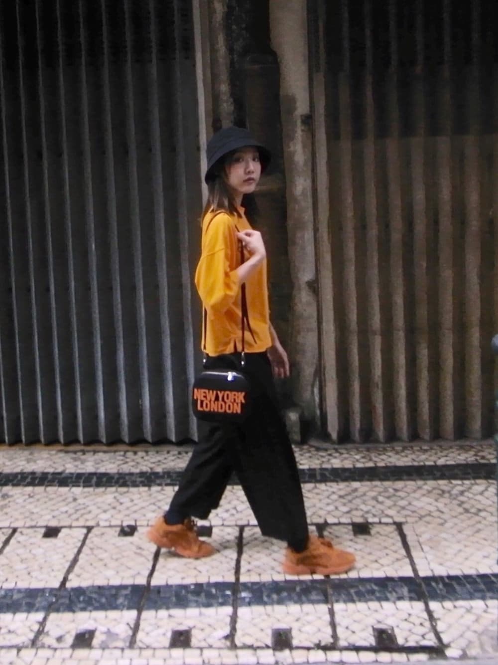 オレンジ系のスニーカー、オレンジ系のTシャツ/カットソー、オレンジ系のショルダーバッグを着用したレディースの春コーディネートの1枚目の写真