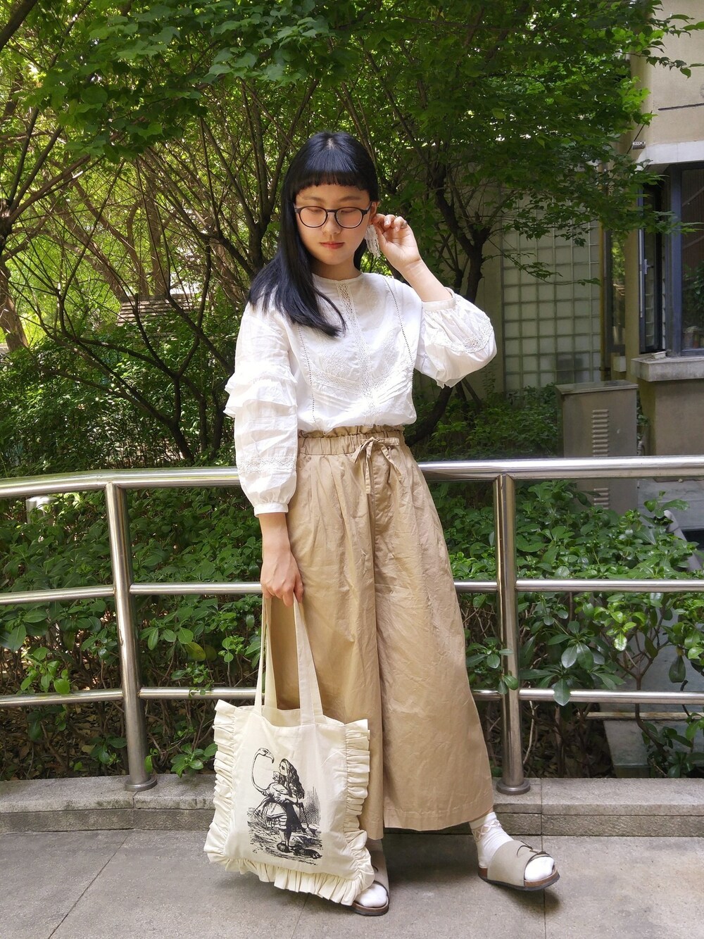 ホワイト系のシャツ/ブラウス、ベージュ系のその他パンツ、ホワイト系のクラッチバッグを着用したレディースの春コーディネートの1枚目の写真