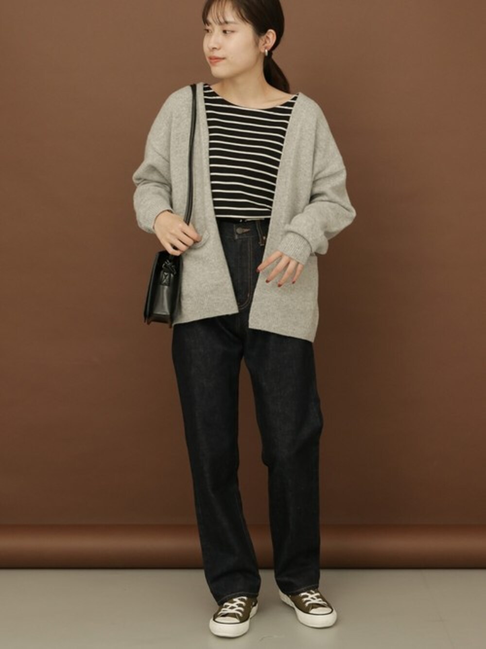 グレー系のカーディガン/ボレロ、ブラック系のTシャツ/カットソー、ブルー系のデニムパンツを着用したレディースの秋コーディネートの1枚目の写真