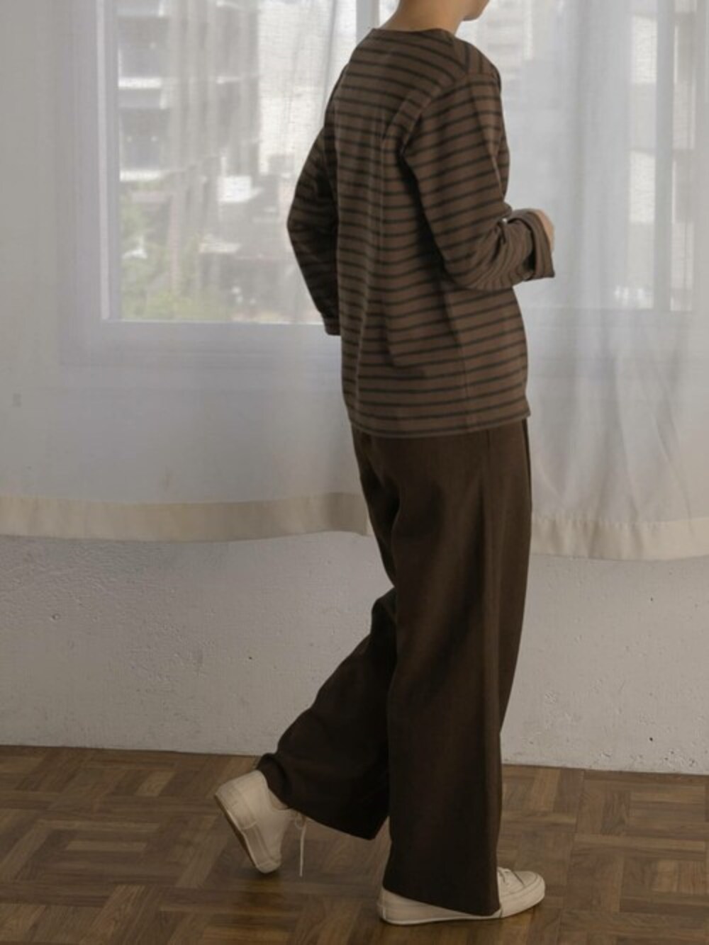 ブラウン系のTシャツ/カットソー、ブラウン系のその他パンツ、ホワイト系のスニーカーを着用したレディースの秋コーディネートの1枚目の写真