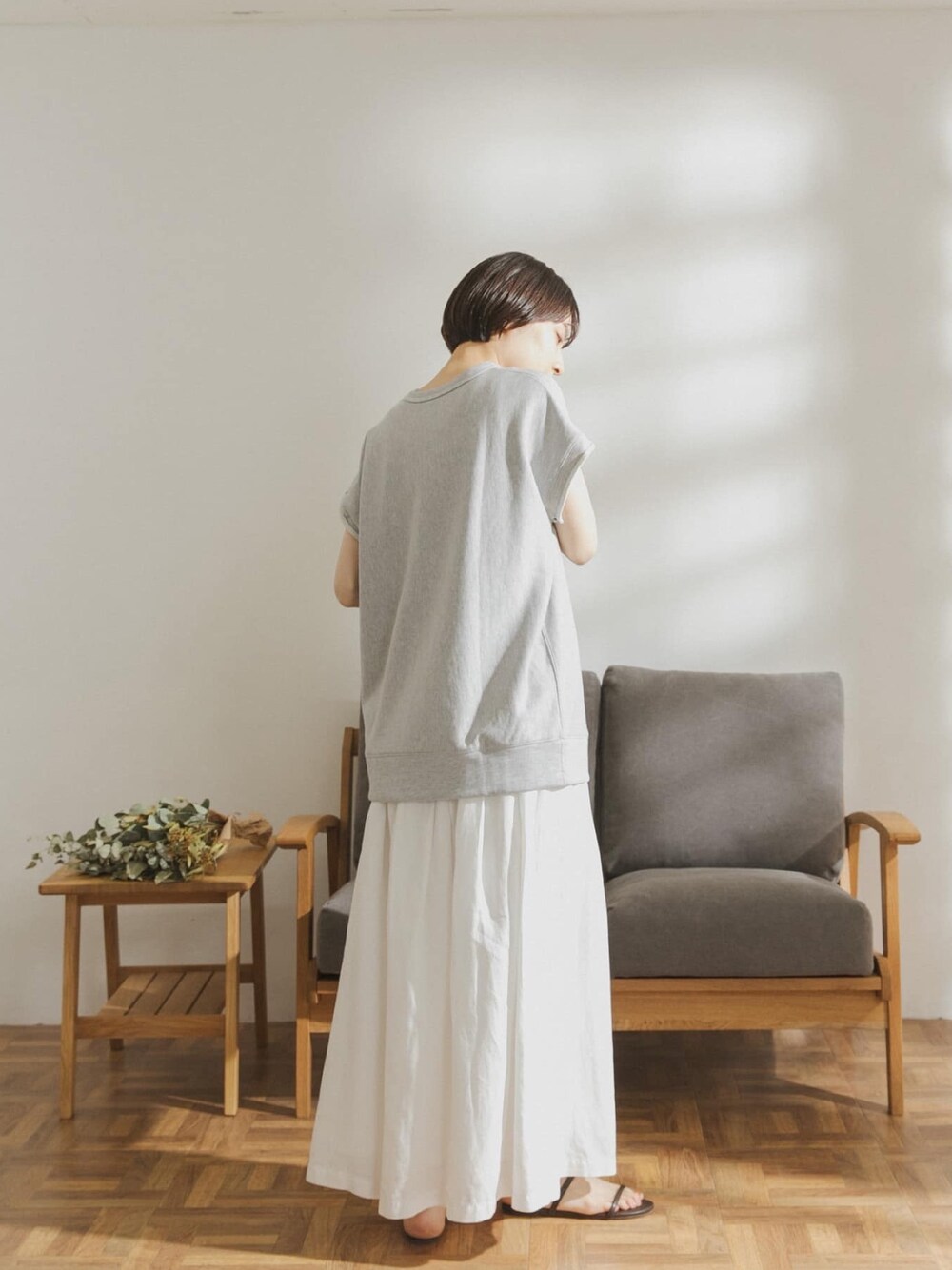 グレー系のTシャツ/カットソー、ホワイト系のスカートを着用したレディースの春コーディネートの1枚目の写真