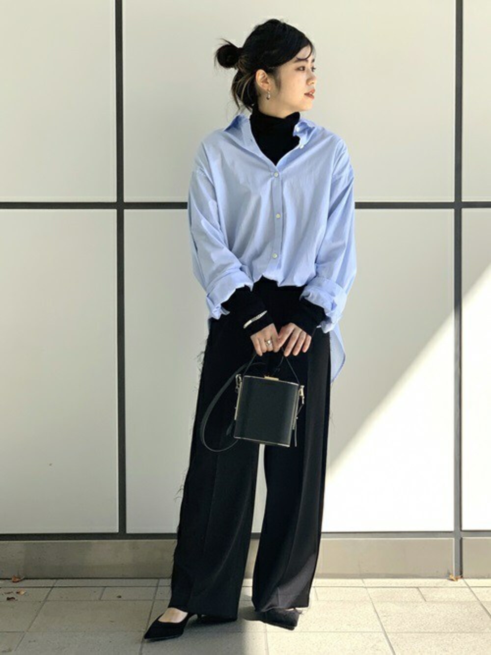 ブルー系のシャツ/ブラウス、ブラック系のニット/セーターを着用したレディースの秋コーディネートの1枚目の写真