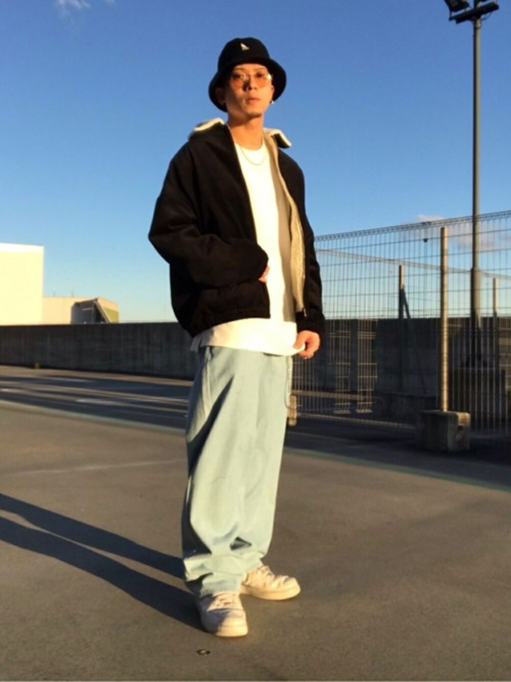 ブラック系のブルゾン、ホワイト系のTシャツ/カットソー、ブルー系のデニムパンツを着用したメンズの冬コーディネートの1枚目の写真
