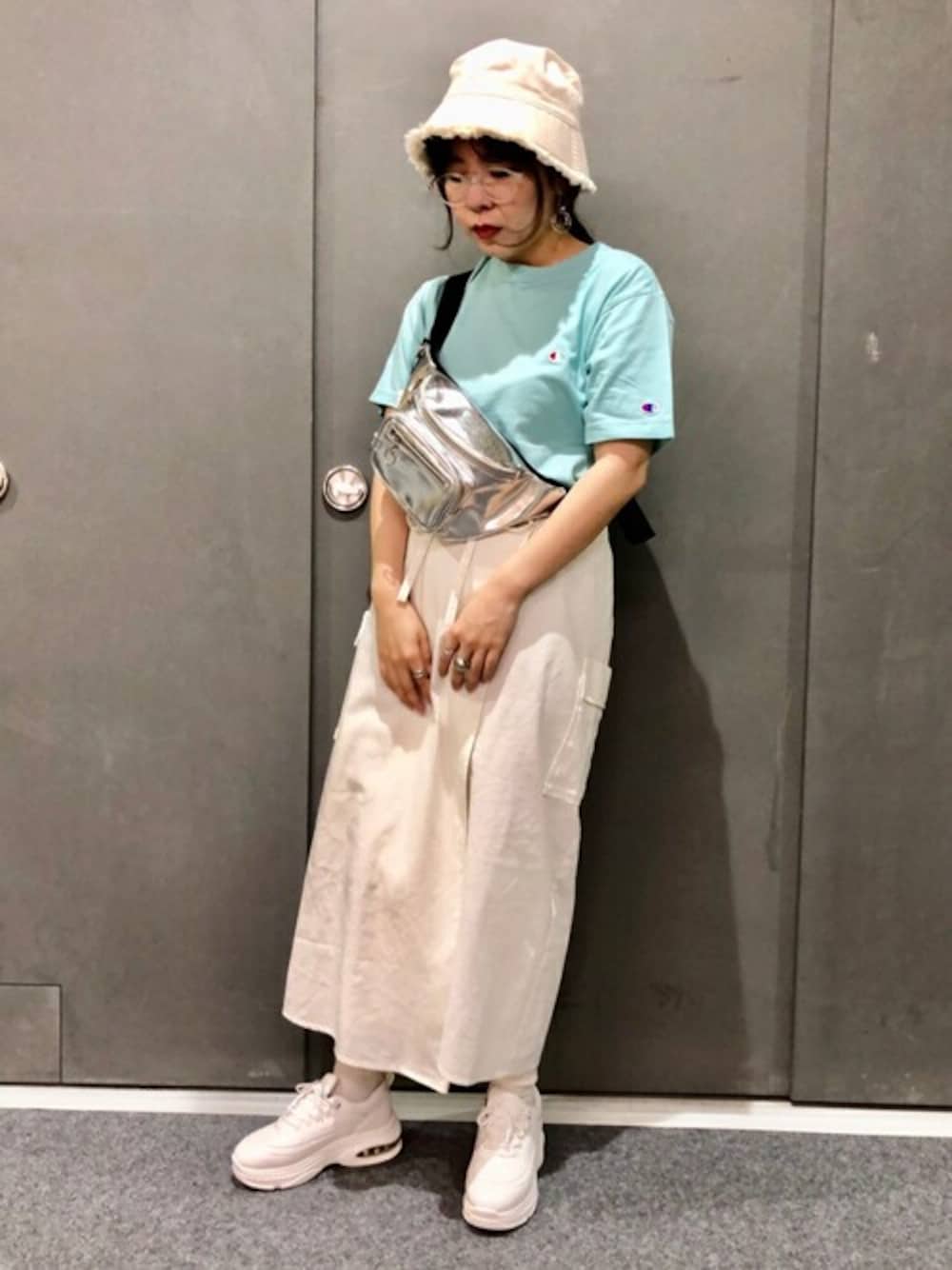 シルバー系のボディバッグ/ウエストポーチ、ホワイト系のスカート、グリーン系のTシャツ/カットソーを着用したレディースの夏コーディネートの1枚目の写真