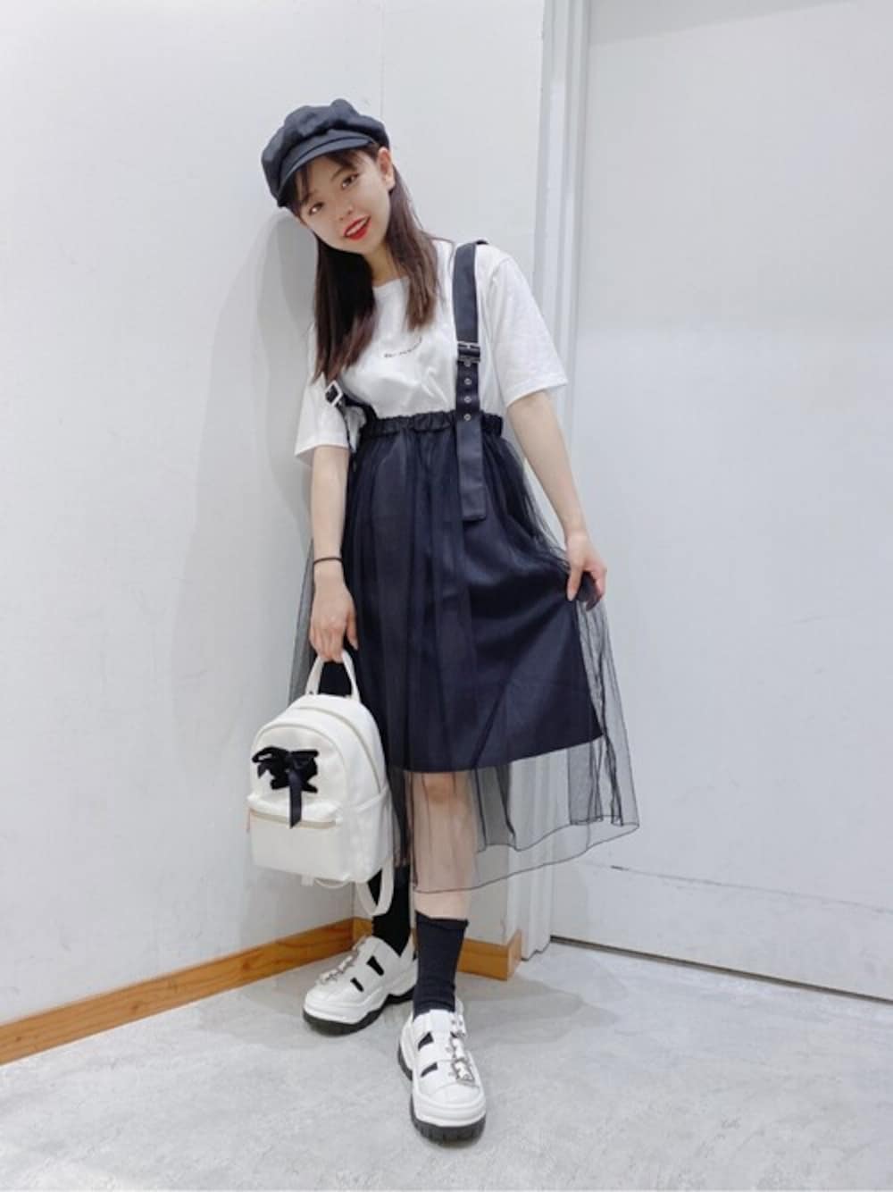 ホワイト系のTシャツ/カットソー、ブラック系のスカート、ホワイト系のサンダルを着用したレディースの夏コーディネートの1枚目の写真