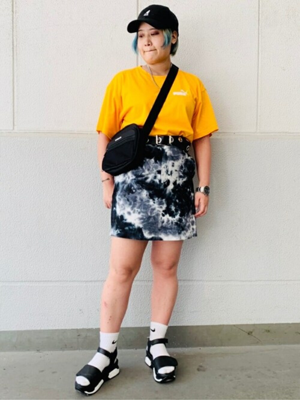 ブラック系のスカート、イエロー系のTシャツ/カットソー、ブラック系のショルダーバッグを着用したレディースの夏コーディネートの1枚目の写真