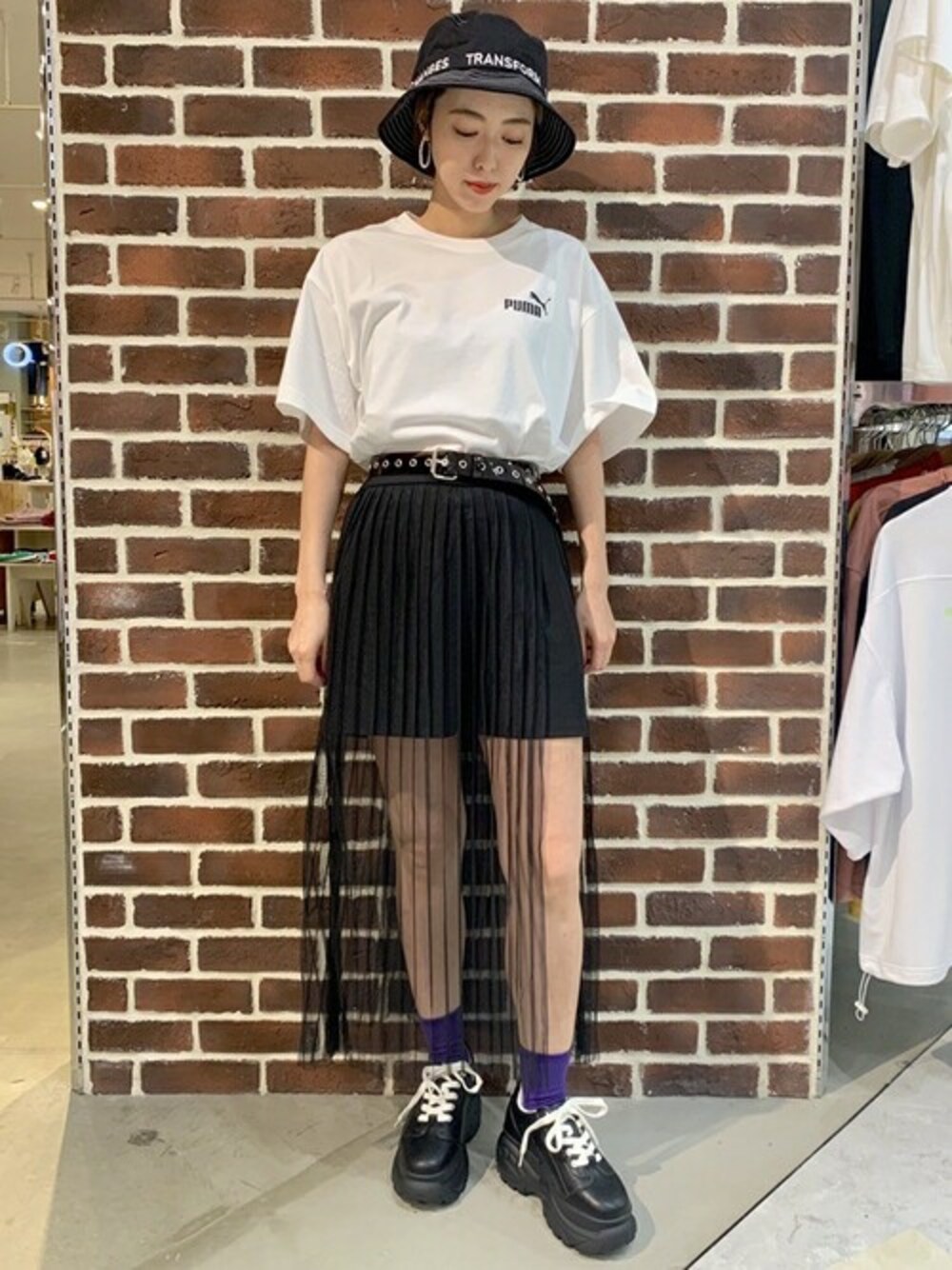 ホワイト系のTシャツ/カットソー、ブラック系のスカート、ブラック系のスニーカーを着用したレディースの夏コーディネートの1枚目の写真