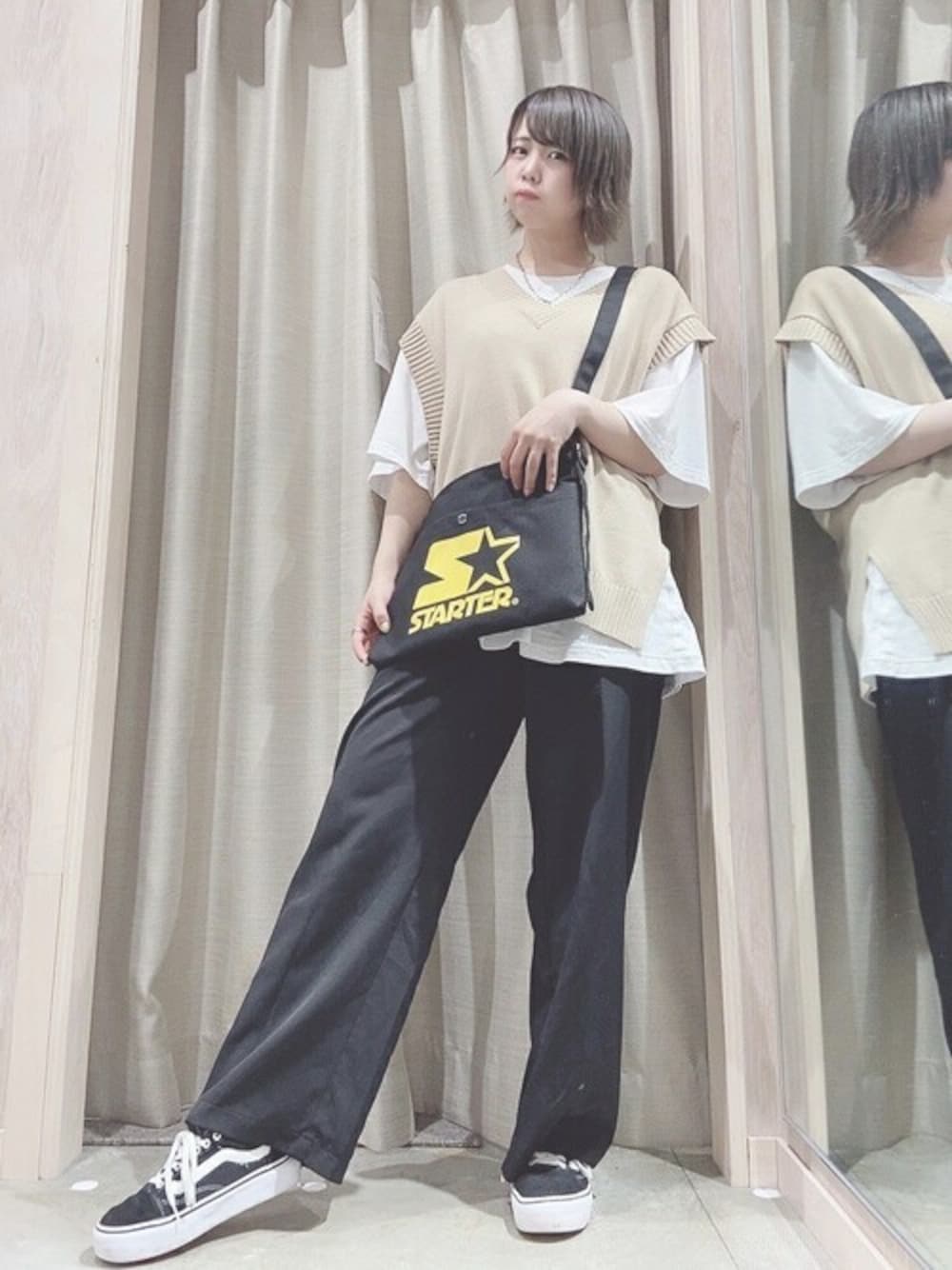 ブラック系のショルダーバッグ、ベージュ系のベスト、ホワイト系のTシャツ/カットソーを着用したレディースの夏コーディネートの1枚目の写真