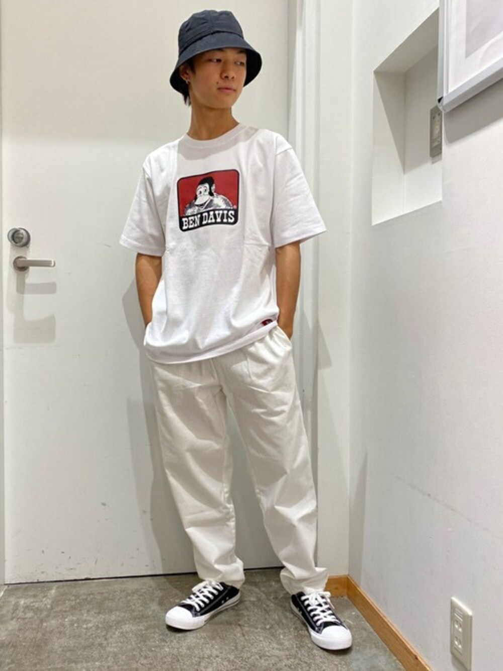 ホワイト系のTシャツ/カットソー、ホワイト系のチノパンツ、ブラック系のスニーカーを着用したメンズの夏コーディネートの1枚目の写真