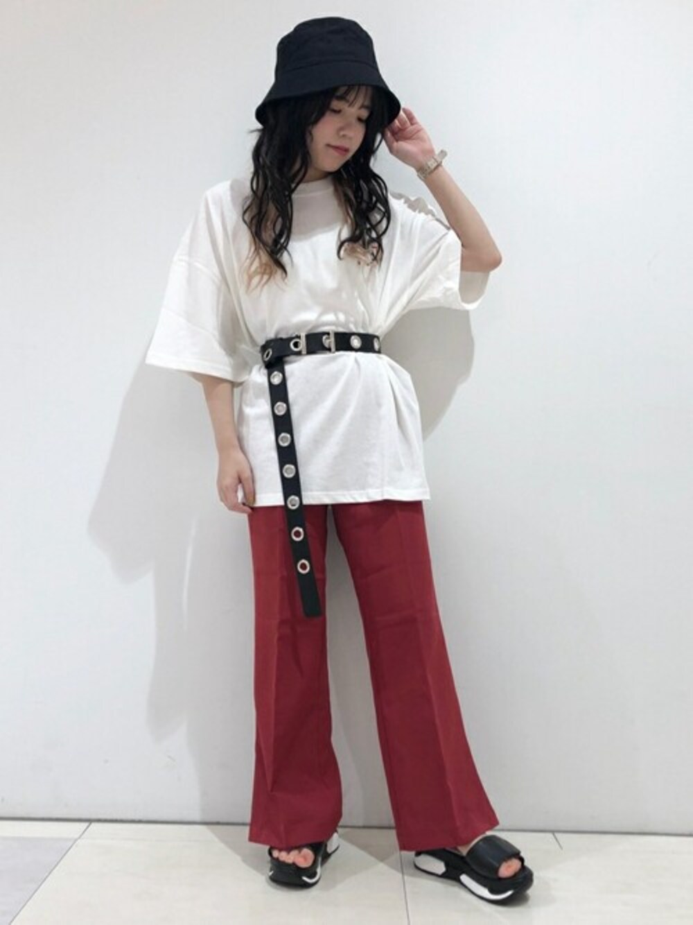 ホワイト系のTシャツ/カットソー、レッド系のスラックス、ブラック系のサンダルを着用したレディースの夏コーディネートの1枚目の写真