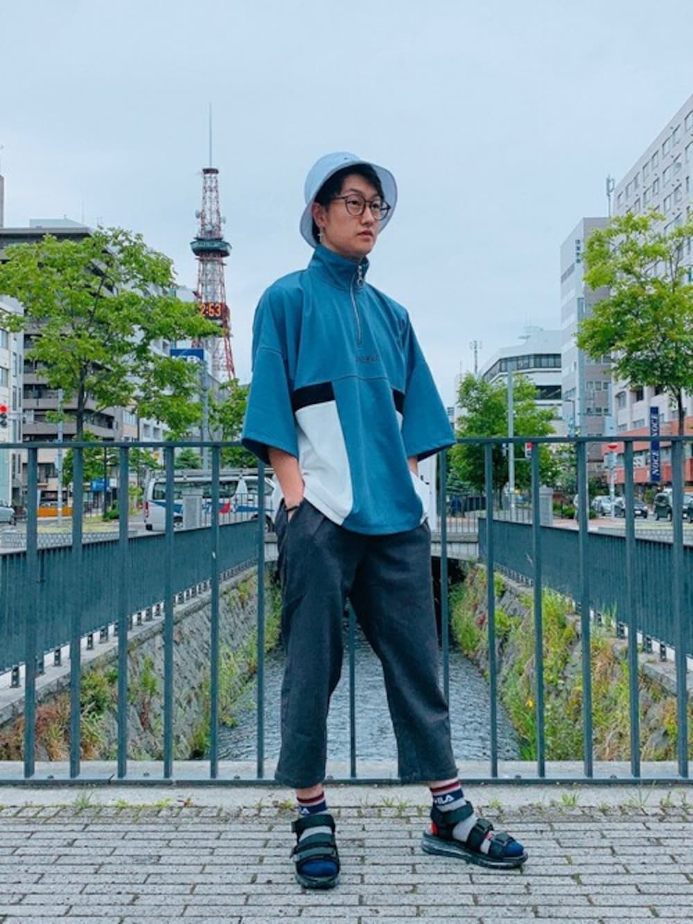 ブルー系のTシャツ/カットソー、グレー系のスラックス、ホワイト系のハットを着用したメンズの夏コーディネートの1枚目の写真