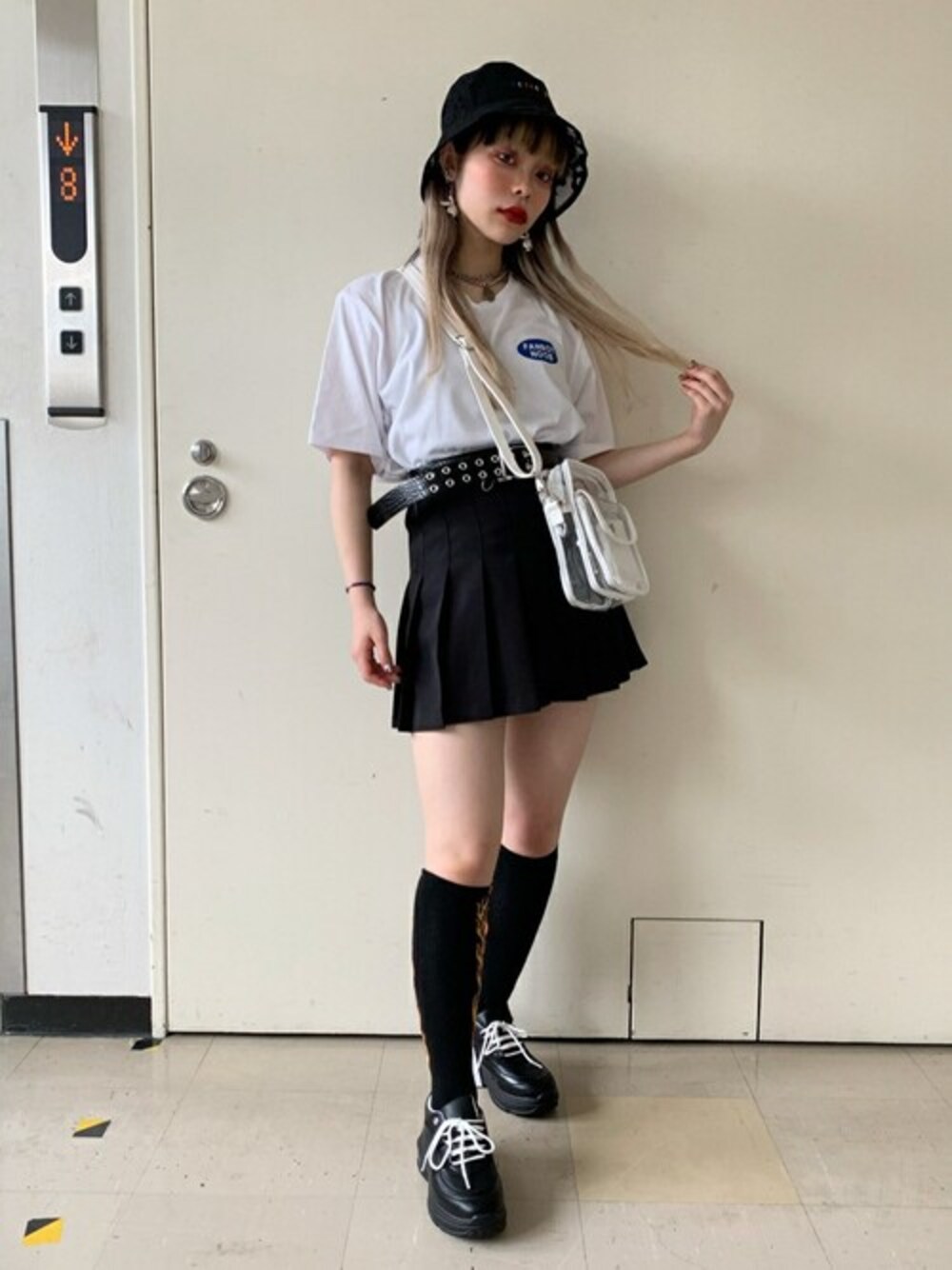 ブラック系のスカート、ホワイト系のTシャツ/カットソー、ホワイト系のショルダーバッグを着用したレディースの夏コーディネートの1枚目の写真