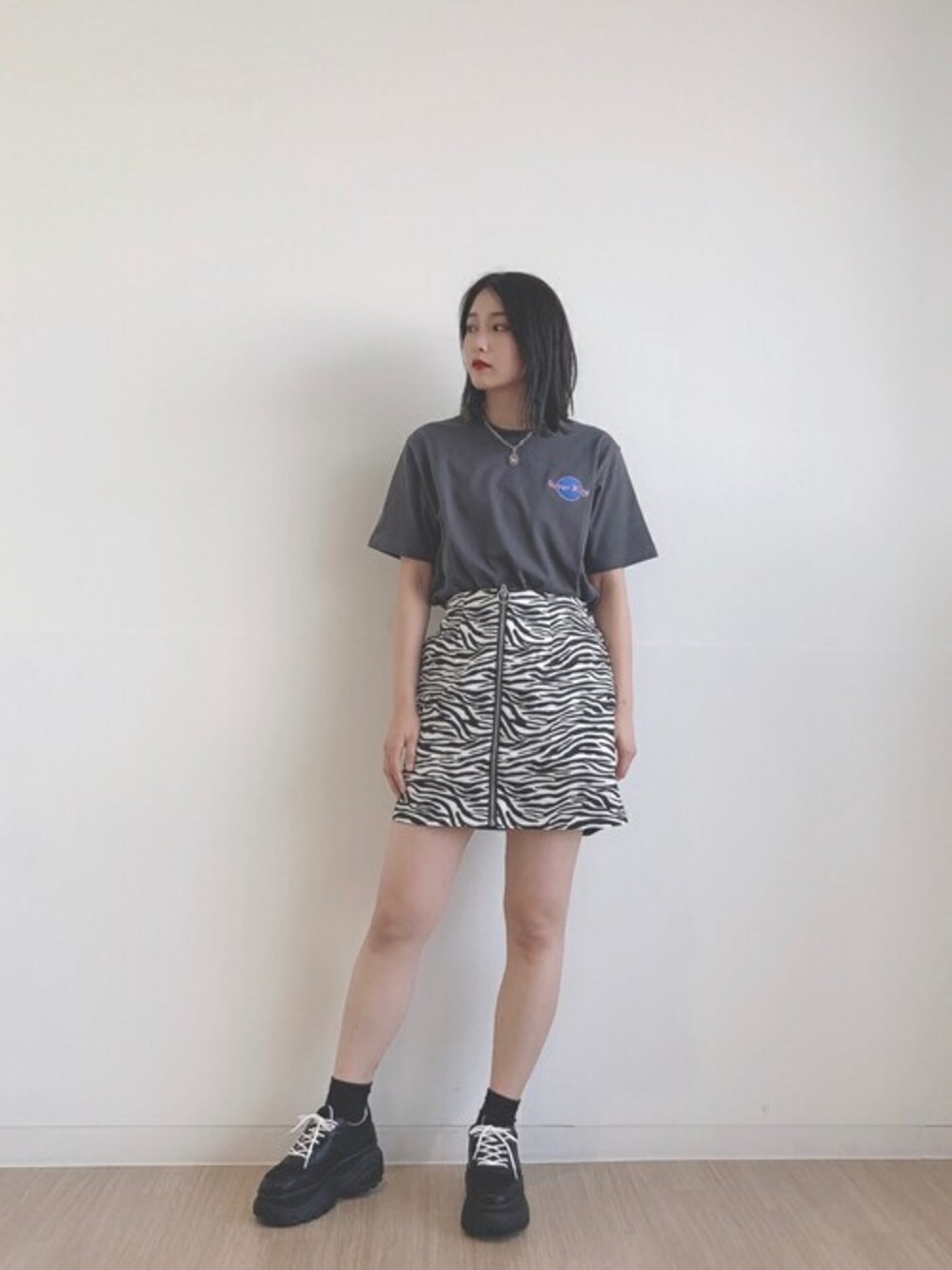 ブラック系のTシャツ/カットソー、ブラック系のスカート、ブラック系のスニーカーを着用したレディースの夏コーディネートの1枚目の写真